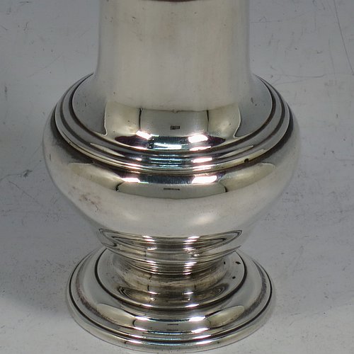 An Antique Georgian George II Sterling Silver pepper pot, having a plain bellied body with applied reeded borders, a hand-pierced pull-off lid with urn-shaped finial, and sitting on a pedestal foot. Made by Samuel Woods of London in 1752. The dimensions of this fine hand-made antique silver pepper pot are height 12 cms (4.75 inches), diameter of main body 5 cms (2 inches), and it weighs approx. 90g (3 troy ounces).    