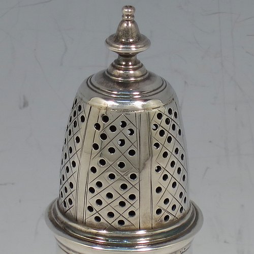 An Antique Georgian George II Sterling Silver pepper pot, having a plain bellied body with applied reeded borders, a hand-pierced pull-off lid with urn-shaped finial, and sitting on a pedestal foot. Made by Samuel Woods of London in 1752. The dimensions of this fine hand-made antique silver pepper pot are height 12 cms (4.75 inches), diameter of main body 5 cms (2 inches), and it weighs approx. 90g (3 troy ounces).    