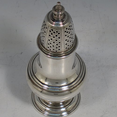 An Antique Georgian George II Sterling Silver pepper pot, having a plain bellied body with applied reeded borders, a hand-pierced pull-off lid with urn-shaped finial, and sitting on a pedestal foot. Made by Samuel Woods of London in 1752. The dimensions of this fine hand-made antique silver pepper pot are height 12 cms (4.75 inches), diameter of main body 5 cms (2 inches), and it weighs approx. 90g (3 troy ounces).    