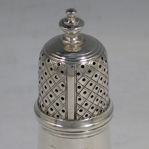 An Antique Victorian Sterling Silver pepper shaker or pot in a George II style, having a plain round bellied body, with reeded borders, pull-off hand-pierced lid with a cast finial, and sitting on a pedestal foot. Made by Nathan & Hayes of Chester in 1897. The dimensions of this fine hand-made antique silver pepper pot or shaker are height 11 cms (4.3 inches), diameter 5 cms (2 inches), and it weighs approx. 85g (2.7 troy ounces).