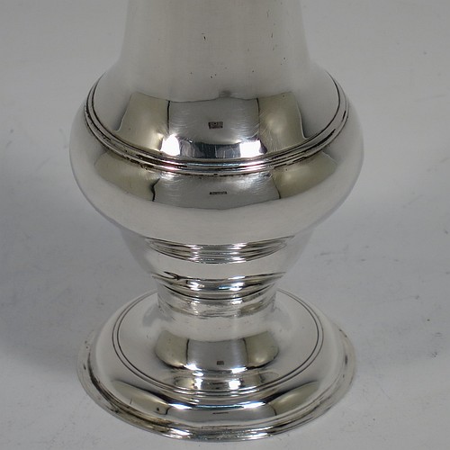 A very handsome Antique Georgian George III Sterling Silver pepper pot, having a plain baluster body with applied reeded borders, a hand-pierced pull-off lid with acorn finial, and sitting on a pedestal foot. Made by John Denziloe of London in 1779. The dimensions of this fine hand-made antique silver pepper pot are height 14 cms (5.5 inches), diameter of main body 5 cms (2 inches), and it weighs approx. 83g (2.7 troy ounces).   