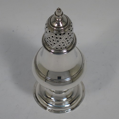 A very handsome Antique Georgian George III Sterling Silver pepper pot, having a plain baluster body with applied reeded borders, a hand-pierced pull-off lid with acorn finial, and sitting on a pedestal foot. Made by John Denziloe of London in 1779. The dimensions of this fine hand-made antique silver pepper pot are height 14 cms (5.5 inches), diameter of main body 5 cms (2 inches), and it weighs approx. 83g (2.7 troy ounces).   