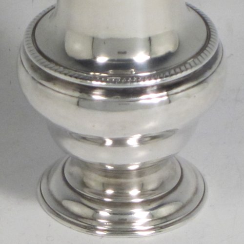 Antique Georgian sterling silver pepper pot, having a plain baluster body with an applied gadroon border, a hand-pierced pull-off lid with swirl finial, and sitting on a pedestal foot. Made by John Delmester of London in 1765. The dimensions of this fine hand-made silver pepper pot are height 11.5 cms (4.5 inches), diameter of main body 4.5 cms (1.75 inches), and it weighs approx. 72g (2.3 troy ounces).   