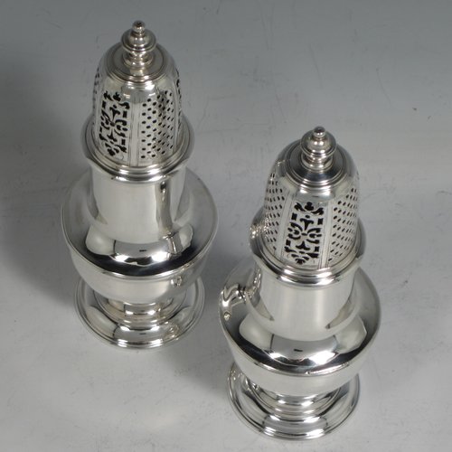 An Antique Georgian sterling silver pair of George II pepper pots, having plain round baluster bodies, with hand-pierced pull-off lids and finials, and sitting on pedestal feet. Made by Thomas Bamford I of London in 1730. The dimensions of these fine hand-made silver pepper pots are height 14.5 cms (5.75 inches), diameter of main body 5 cms (2 inches), and they weigh a total of approx. 257g (8.3 troy ounces).   