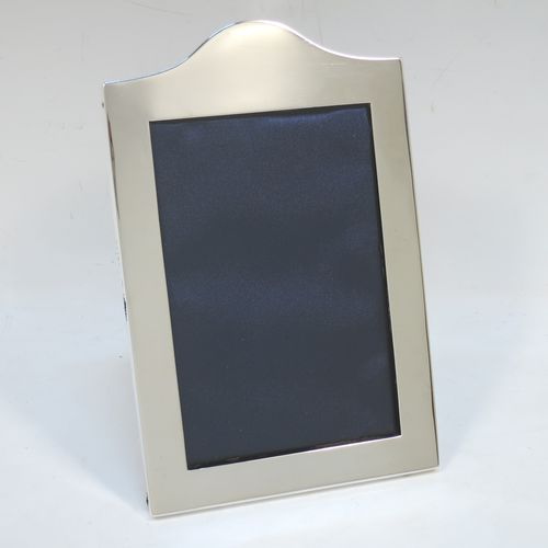 A very handsome Antique Sterling Silver portrait photograph frame, having a hand-made very plain rectangular body with pinned edges and domed upper border, and a dark blue velvet-backed easel frame. Made by William Comyns of London in 1911. The internal dimensions of this fine hand-made antique silver photo frame are height 13 cms (5 inches), and width 9 cms (3.5 inches).   