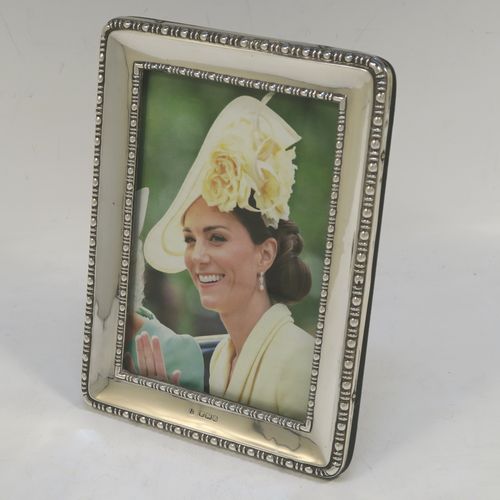 A very pretty Antique Sterling Silver portrait photograph frame, having a hand-made rectangular body with pinned edges, a double pearl and dart border, and an original wood-backed easel frame. Made by James and Walter Deakin of Sheffield 1915. The internal dimensions of this fine hand-made antique silver photo frame are height 13 cms (5.25 inches), and width 8.5 cms (3.3 inches).  