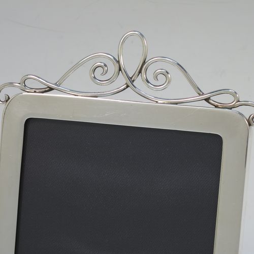 A handsome Antique Edwardian Sterling Silver portrait photograph frame, having a plain hand-made rectangular body with rounded top corners, a pretty applied wire-work top mount, and a maroon leather-backed easel frame. Made by J. Batson and Sons of London in 1902. The internal dimensions of this fine hand-made antique silver photo frame are height 13 cms (5.25 inches), and width 9 cms (3.5 inches).  