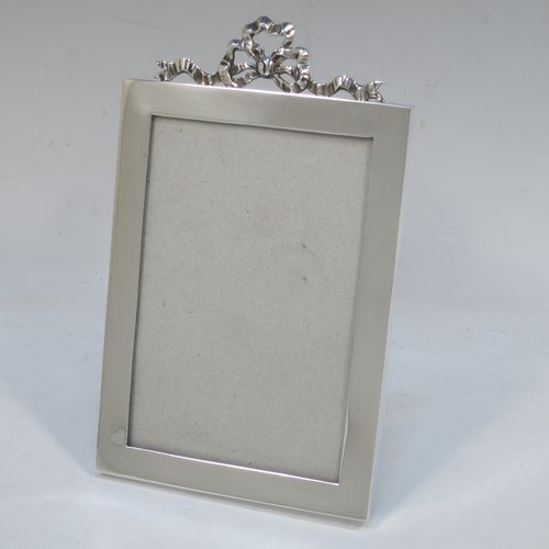 A very elegant Antique Edwardian Sterling Silver photograph frame, having a plain hand-made rectangular portrait body, an applied cast ribbon and bow top mount, and a black wood-backed easel frame. Made by the Asprey Brothers of London in 1902. The internal dimensions of this fine hand-made antique silver photo frame are height 13 cms (5 inches), by width 8.5 cms (3.3 inches).  