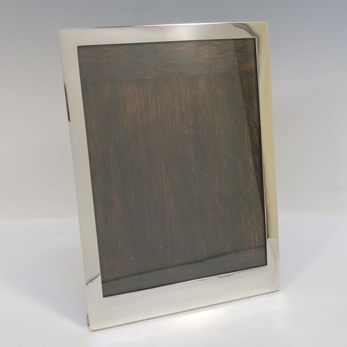 A large and handsome Sterling Silver portrait photograph frame, having a hand-made plain rectangular body, and an original brown wood-backed easel frame. This elegant silver photo frame was made by Stokes and Ireland of Chester in 1928. The internal dimensions of this fine hand-made silver photo frame are height 23 cms (9 inches), and width 17 cms (6.75 inches).   