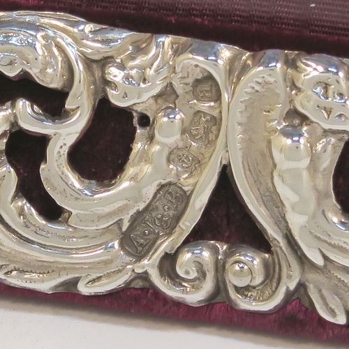 A very pretty and unusual Antique Victorian Sterling Silver double photograph frame, having a hand-pierced border with scroll, floral, and animal decoration, and all pinned to a maroon leather-backed easel frame. This beautiful antique silver double photo frame was made by Synyer and Beddoes of Birmingham in 1900. The internal dimensions of both of these hand-made antique silver photo frame apertures are 12.5 cms (5 inches), and width 9 cms (3.5 inches) high.  