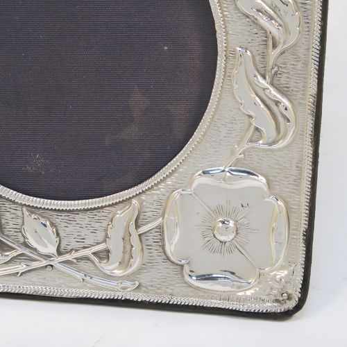 A very pretty Art Nouveau Antique Edwardian Sterling Silver photograph frame, having a round aperture with a glass cover, surrounded by rope-twist border and hand-chased floral poppy decoration, and all pinned to an original blue velvet-backed easel frame. This beautiful antique silver photo frame was made by A. and J. Zimmerman of Birmingham in 1905. The internal dimensions of this fine hand-made Art Nouveau antique silver photo frame are 8 cms (3 inches) in diameter.   