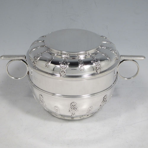 Antique Victorian sterling silver porringer and lid, having a round baluster body, a round lift-off lid, two oxe-eye side handles, all decorated with applied strap-work motifs, and sittng on a collet foot. Made by Holland, Aldwinckle, and Slater of London 1897. The dimensions of this fine hand-made silver porringer and lid are height 9 cms (3.5 inches), spread across arms 16. cms (6.5 inches), and it weighs approx. 324g (10.5 troy ounces).