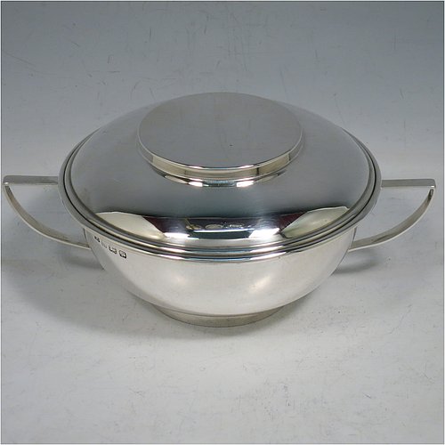 A Sterling Silver porringer and lid, having a plain round bellied body, with two scroll side handles, a pull-off cover, and all sitting on a collet foot. Made by George Unite of Birmingham in 1916. The dimensions of this fine hand-made silver porringer and lid are height 7 cms (2.75 inches), spread across arms 16.5 cms (6.5 inches), and it weighs approx. 218g (7 troy ounces).   