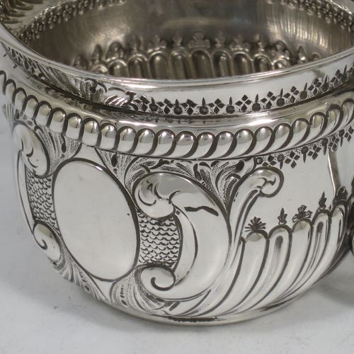 A very handsome Antique Sterling Silver porringer, having a round bellied body with hand-chased fluted and scroll decoration, with a vacant oval cartouche on one side, two scroll side-handles, and sitting on a flat base. Made by S. Blanckensee and Son Lt., of Birmingham in 1919. The dimensions of this fine hand-made antique silver porringer are height 8 cms (3.25 inches), spread across handles 16.5 cms (6.5 inches), and it weighs approx. 200g (6.5 troy ounces).   