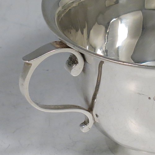 An Antique Edwardian Sterling Silver porringer, having a plain round baluster body, with two scroll side handles, and sitting on a collet foot. Made by Henry Hayes of Birmingham in 1902. The dimensions of this fine hand-made antique silver poringer are height 6.5 cms (2.5 inches), spread across arms 13 cms (5 inches), and it weighs approx. 125g (4 troy ounces).    