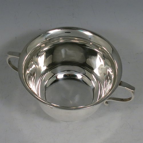 An Antique Edwardian Sterling Silver porringer, having a plain round baluster body, with two scroll side handles, and sitting on a collet foot. Made by Henry Hayes of Birmingham in 1902. The dimensions of this fine hand-made antique silver poringer are height 6.5 cms (2.5 inches), spread across arms 13 cms (5 inches), and it weighs approx. 125g (4 troy ounces).    