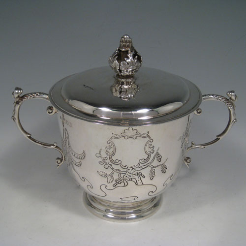 Antique Edwardian sterling silver hand-chased porringer with cast figural handles, cast floral finial, and floral hand-chasing. Made by Skinner and Co., of London in 1904. Height 19 cms (7.5 inches), spread across arms 24 cms (9.5 inches). Weight approx. 777g (25 troy ounces).