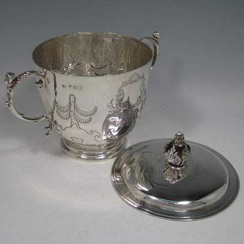 Antique Edwardian sterling silver hand-chased porringer with cast figural handles, cast floral finial, and floral hand-chasing. Made by Skinner and Co., of London in 1904. Height 19 cms (7.5 inches), spread across arms 24 cms (9.5 inches). Weight approx. 777g (25 troy ounces).