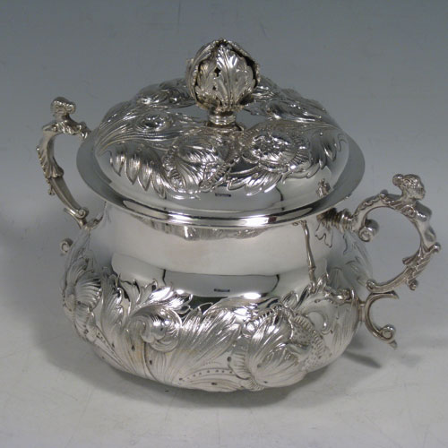 Antique Edwardian sterling silver porringer, having a round baluster body with hand-chased floral decoration, a gold-gilt interior, a lift-off lid with cast floral finial, and two cast figural handles, all in original satin and velvet-lined presentation box. Made by Carrington and Co., of London in 1907. The dimensions of this fine hand-made silver porringer and lid are height 14 cms (5.5 inches), spread across arms 19 cms (7.5 inches), and it weighs approx. 553g (17.8 troy ounces).   