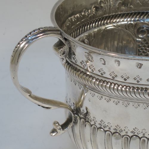 A very handsome Antique Queen Anne Britannia Standard Silver porringer, having a round bellied body with hand-chased fluted and scroll decoration, with a round cartouche on one side, two scroll side-handles, and sitting on a flat base. Made by Timothy Ley of London in 1714. The dimensions of this fine hand-made antique Britannia silver porringer are height 11 cms (4.25 inches), spread across handles 18 cms (7 inches), and it weighs approx. 284g (9 troy ounces). Please note that this item has an engraved contemporaneous set of initials in the cartouche.