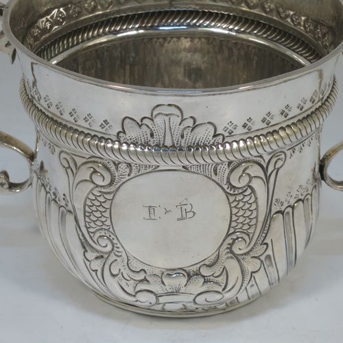 A very handsome Antique Queen Anne Britannia Standard Silver porringer, having a round bellied body with hand-chased fluted and scroll decoration, with a round cartouche on one side, two scroll side-handles, and sitting on a flat base. Made by Timothy Ley of London in 1714. The dimensions of this fine hand-made antique Britannia silver porringer are height 11 cms (4.25 inches), spread across handles 18 cms (7 inches), and it weighs approx. 284g (9 troy ounces). Please note that this item has an engraved contemporaneous set of initials in the cartouche.