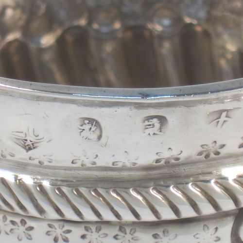 A very handsome Antique Queen Anne Britannia Standard Silver porringer, having a round bellied body with hand-chased fluted and scroll decoration, with a round cartouche on one side, two scroll side-handles, and sitting on a flat base. Made by Seth Lofthouse (Prob.) of London in 1709. The dimensions of this fine hand-made antique Britannia silver porringer are height 8 cms (3 inches), spread across handles 16 cms (6.25 inches), and it weighs approx. 156g (5 troy ounces).  