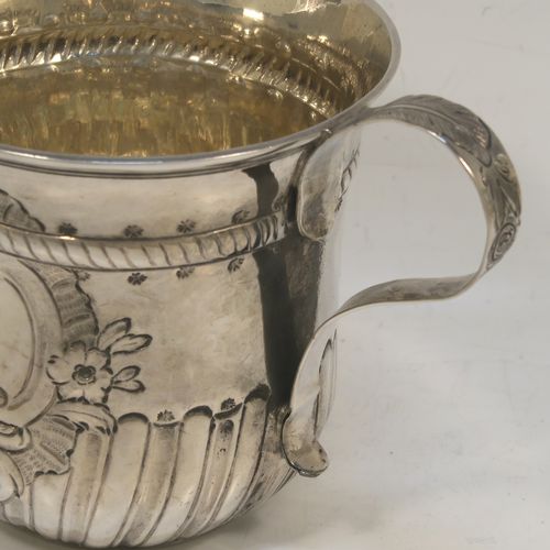 A very handsome Antique Georgian Sterling Silver porringer, having a round bellied body with hand-chased fluted and scroll decoration, with an oval vacant cartouche on one side, two scroll side-handles with leaf decoration, a lemon gold gilt interior, and sitting on a flat base. This beautiful antique silver porringer was made by Thomas Pitts I (poss.) of London in 1760. The dimensions of this fine hand-made antique silver porringer are height 10 cms (4 inches), spread across handles 16.5 cms (6.5 inches), and it weighs approx. 225g (7.3 troy ounces).   