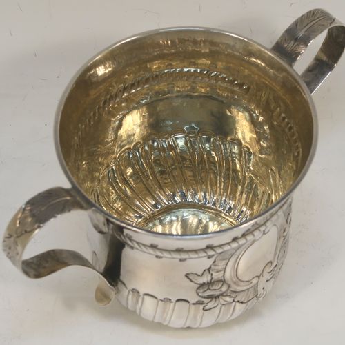 A very handsome Antique Georgian Sterling Silver porringer, having a round bellied body with hand-chased fluted and scroll decoration, with an oval vacant cartouche on one side, two scroll side-handles with leaf decoration, a lemon gold gilt interior, and sitting on a flat base. This beautiful antique silver porringer was made by Thomas Pitts I (poss.) of London in 1760. The dimensions of this fine hand-made antique silver porringer are height 10 cms (4 inches), spread across handles 16.5 cms (6.5 inches), and it weighs approx. 225g (7.3 troy ounces).   