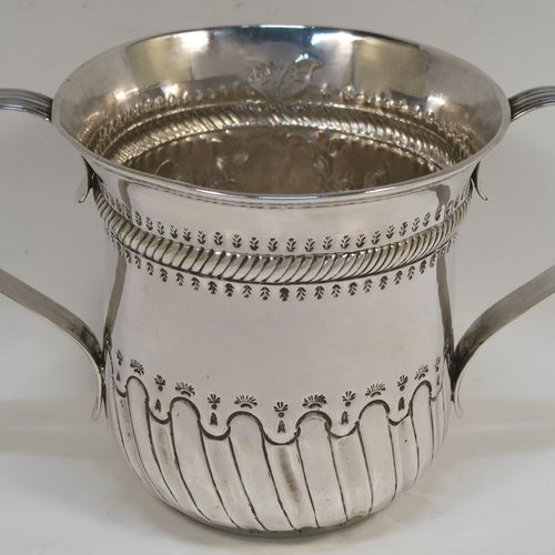 A beautiful Antique Georgian Sterling Silver porringer, having a round bellied body with hand-chased fluted and scroll decoration, with a vacant cartouche on one side surrounded by hand-chased floral decoration, two scroll and reeded side-handles, and all sitting on a flat base. This pretty antique silver poringer was made by William Cattell of London in 1778. The dimensions of this fine hand-made antique silver porringer are height 11.5 cms (4.5 inches), spread across handles 19 cms (7.5 inches), and it weighs approx. 317g (10.2 troy ounces).   