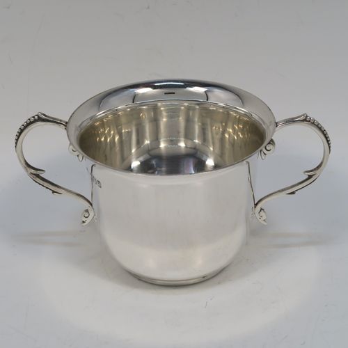 A handsome Antique Victorian Sterling Silver porringer, having a plain round bellied body, two scroll side handles with beaded decoration, and sitting on a flat base. This elegant silver porringer was made by D. and J. Welby of London in 1896. The dimensions of this fine hand-made antique silver porringer are height 7.5 cms (3 inches), spread across arms 14.5 cms (5.75 inches), and it weighs approx. 153g (5 troy ounces).  