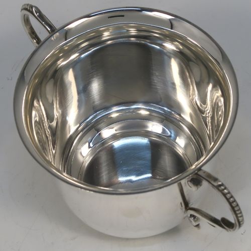 A handsome Antique Victorian Sterling Silver porringer, having a plain round bellied body, two scroll side handles with beaded decoration, and sitting on a flat base. This elegant silver porringer was made by D. and J. Welby of London in 1896. The dimensions of this fine hand-made antique silver porringer are height 7.5 cms (3 inches), spread across arms 14.5 cms (5.75 inches), and it weighs approx. 153g (5 troy ounces).  