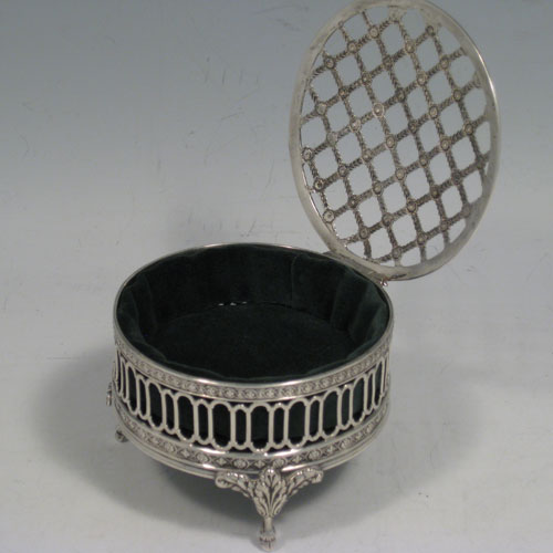    Antique Edwardian sterling silver pot-pourri holder. Having a round hand-pierced lid and body, sitting on three cast foliate feet. Made by William Comyns of London in 1907. Diameter 8 cms (3.25 inches), height 6 cms (2.25 inches).