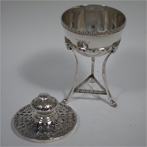 A Sterling Silver pot pourri holder, having a round bellied body sitting in a cast three-legged frame, with hoof feet, applied cast rams heads and floral borders, a pull-off lid with hand-engraved and pierced decoration surrounding a round knop handle. Made by S. Blanckensee and Sons of Birmingham in 1924. The dimensions of this fine hand-made silver pot-pourri holder are height 14 cms (5.5 inches), diameter 7 cms (2.75 inches), and it weighs approx. 147g (4.7 troy ounces).    