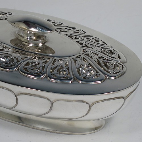 An Antique Edwardian Sterling Silver pot pourri holder, having an oval body with hand-chased fluted decoration, a lift-off lid with a cast oval handle and hand-pierced floral and scroll work, all sitting on an oval collet foot. Made by Walker and Hall of Sheffield in 1908. The dimensions of this fine hand-made antique silver pot-pourri holder are length 16 cms (6.5 inches), width height 9 cms (3.5 inches), height 7 cms (2.75 inches), and it weighs approx. 308g (10 troy ounces)   