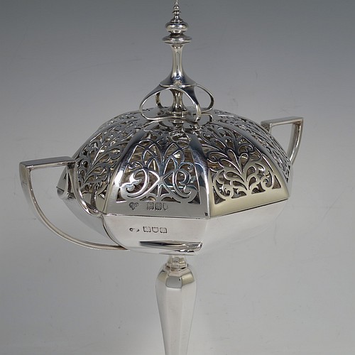 A very handsome and large Antique Edwardian Sterling Silver pot pourri holder in an Art Nouveau style, having an unusual trophy shaped body with two-side-handles, a lift off hand-pierced and panelled lid with cast urn-shaped finial, and all sitting on an octagonal pedestal foot. Made by Goldsmiths and Silversmiths of London in 1907. The dimensions of this fine hand-made antique silver pot-pourri holder are height  28 cms (11 inches), spread across arms 18.5 cms (7.25 inches), and it weighs approx. 482g (15.5 troy ounces)    