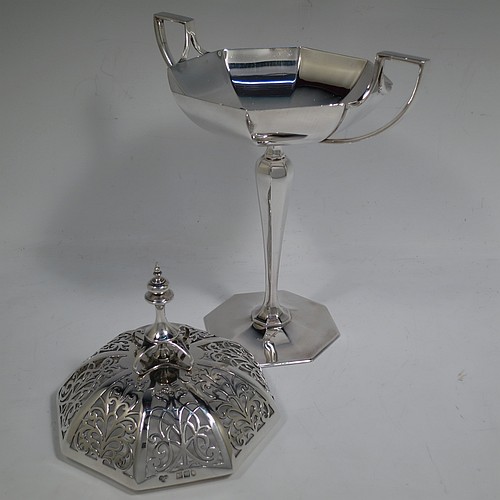 A very handsome and large Antique Edwardian Sterling Silver pot pourri holder in an Art Nouveau style, having an unusual trophy shaped body with two-side-handles, a lift off hand-pierced and panelled lid with cast urn-shaped finial, and all sitting on an octagonal pedestal foot. Made by Goldsmiths and Silversmiths of London in 1907. The dimensions of this fine hand-made antique silver pot-pourri holder are height  28 cms (11 inches), spread across arms 18.5 cms (7.25 inches), and it weighs approx. 482g (15.5 troy ounces)    