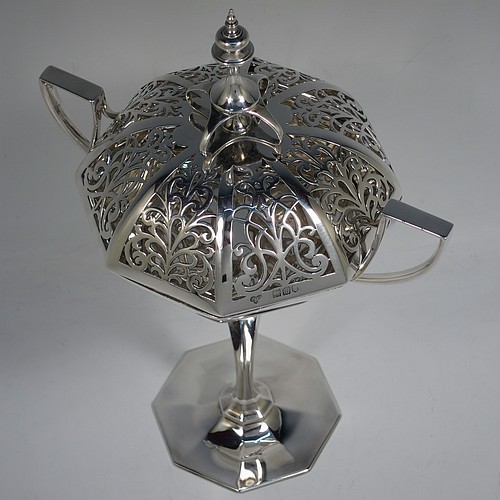 A very handsome and large Antique Edwardian Sterling Silver pot pourri holder in an Art Nouveau style, having an unusual trophy shaped body with two-side-handles, a lift off hand-pierced and panelled lid with cast urn-shaped finial, and all sitting on an octagonal pedestal foot. Made by Goldsmiths and Silversmiths of London in 1907. The dimensions of this fine hand-made antique silver pot-pourri holder are height  28 cms (11 inches), spread across arms 18.5 cms (7.25 inches), and it weighs approx. 482g (15.5 troy ounces)    