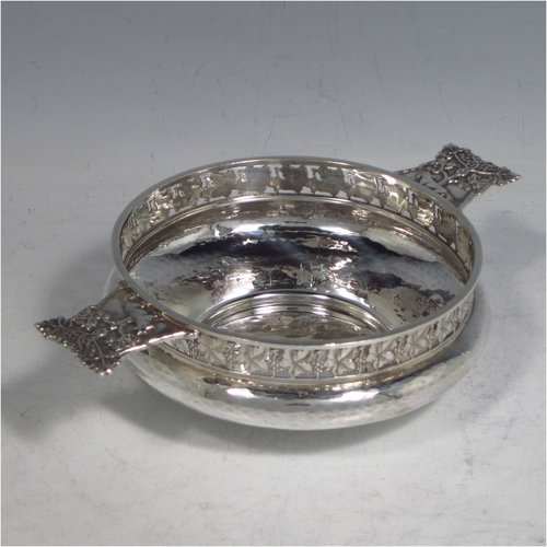 A Sterling silver Arts & Crafts style quaich, having a round baluster body with hand-hammered decoration, a hand-pierced grape-vine border, with two cast side-handles showing a scene with fox and tree, and all sitting on a flat base. Made by A. E. Jones of Birmingham in 1928. The dimensions of this fine hand-made silver Arts and Crafts quaich are diameter of body 12 cms (4.75 inches), height 4 cms (1.5 inches), and it weighs approx. 151g (4.9 troy ounces). 