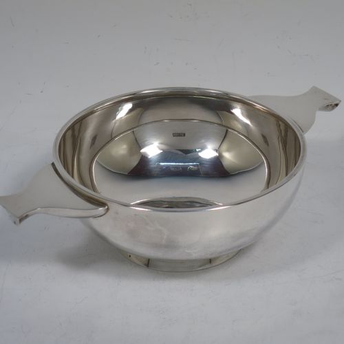 A handsome Sterling Silver quaich, having a very plain round body, with two side handles, sitting on a collet foot. Made by Wakely and Wheeler of London in 1995. The dimensions of this fine hand-made silver quaich are diameter of body 11.5 cms (4.5 inches), height 5 cms (2 inches), and it weighs approx. 188g (6 troy ounces).    