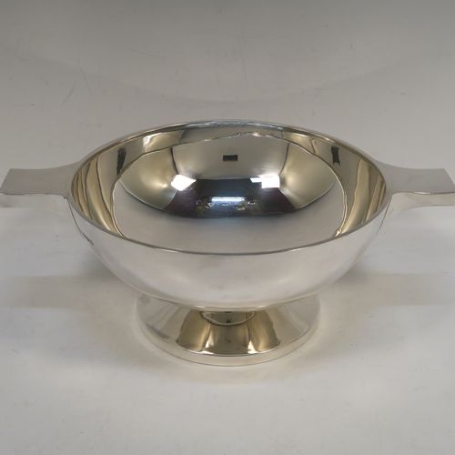 A handsome and very large Sterling Silver quaich, having a very plain round body, with two side handles, and sitting on a pedestal foot. This beautiful silver quaich bowl was made by Walker and Hall of Sheffield in 1937. The dimensions of this fine hand-made silver quaich bowl are diameter of body 20 cms (8 inches), height 10 cms (4 inches), and it weighs approx. 569g (18 troy ounces).