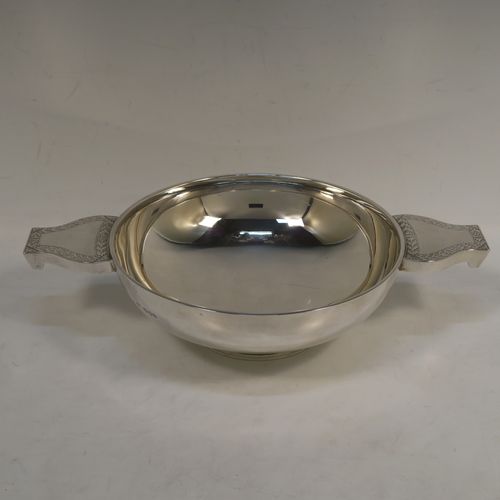 A large and handsome Sterling Silver quaich, having a very plain round body, with two side handles having hand-engraved geometrical engraving, and sitting on a collet foot. This elegant silver quaich was made by Robert Stebbings of London in 1927. The dimensions of this fine hand-made sterling silver quaich are diameter of body 18 cms (7 inches), height 6.5 cms (2.5 inches), and it weighs approx. 423g (13.6 troy ounces).  