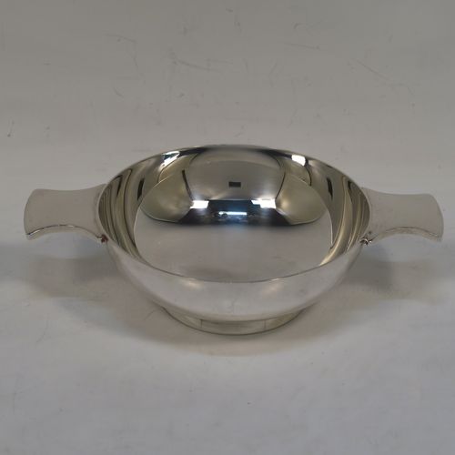 A handsome Scottish Sterling Silver quaich, having a very plain round body, with two side handles, sitting on a collet foot. This elegant silver quaich was made by Francis Howard of Edinburgh in 2009. The dimensions of this fine hand-made silver Scottish quaich are diameter of body 9 cms (3.5 inches), height 3 cms (1.25 inches), and it weighs approx. 124g (4 troy ounces).  