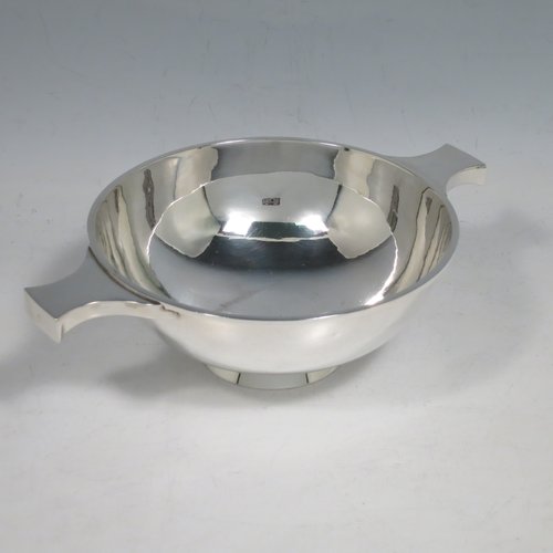 A Sterling Silver Scottish quaich, having a very plain round body, with two side handles, sitting on a collet foot. Made by Hamilton & Inches of Edinburgh in 1977. The dimensions of this fine hand-made silver quaich are diameter of body 13 cms (5 inches), height 5 cms (2 inches), and it weighs approx. 217g (7 troy ounces).    