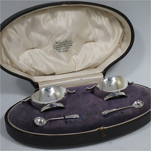 A handsome pair of Scottish Sterling Silver small quaichs, having very plain round bodies, with two side handles, and sitting on collet feet, together with two matching sterling silver Old English pattern spoons. All in their original cream satin and blue velvet-lined presentation box. The quaichs made by Wilson and Sharp of Edinburgh in 1921. The dimensions of these fine hand-made silver quaichs are diameter of body 5.5 cms (2.25 inches), height 2.5 cms (1 inch), and they weigh a total of approx. 90g (3 troy ounces).    