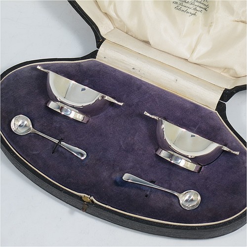 A handsome pair of Scottish Sterling Silver small quaichs, having very plain round bodies, with two side handles, and sitting on collet feet, together with two matching sterling silver Old English pattern spoons. All in their original cream satin and blue velvet-lined presentation box. The quaichs made by Wilson and Sharp of Edinburgh in 1921. The dimensions of these fine hand-made silver quaichs are diameter of body 5.5 cms (2.25 inches), height 2.5 cms (1 inch), and they weigh a total of approx. 90g (3 troy ounces).    