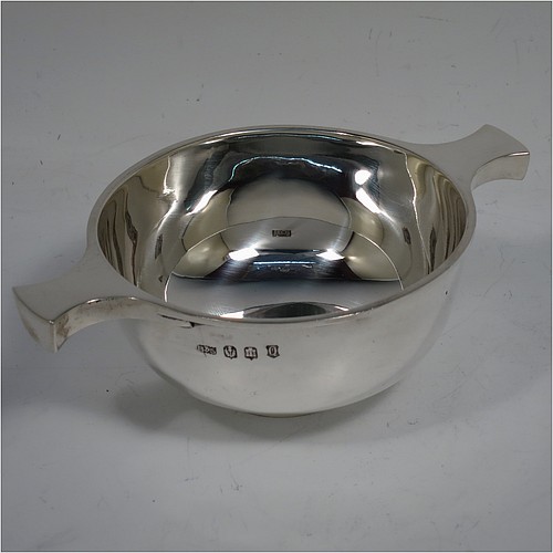 A very handsome Sterling Silver Scottish quaich, having a very plain round body, with two side handles, and sitting on a collet foot. Made by Brook and Sons of Edinburgh in 1921. The dimensions of this fine hand-made silver quaich are diameter of body 10 cms (4 inches), height 5 cms (2 inches), and it weighs approx. 160g (5 troy ounces).    