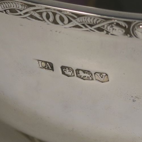 A very handsome, large, and heavy Sterling Silver Celtic style quaich, having a very plain round body, with two cast side handles in a Celtic or Cymmric style, a matching applied border, and sitting on a collet foot. This beautiful silver quaich bowl was made by Henry Atkins of Sheffield in 1938. The dimensions of this fine hand-made silver Celtic style silver quaich are diameter of body 19 cms (7.5 inches), height 7 cms (2.75 inches), and it weighs approx. 670g (21.6 troy ounces).