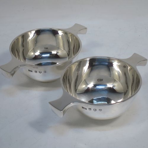 A handsome pair of Sterling Silver Scottish quaichs, having very plain round bodies, with two side handles, sitting on collet feet. Made by Brook & Son of Edinburgh in 1935. The dimensions of these fine hand-made Scottish silver quaichs are diameter of bodies 8.5 cms (3.3 inches), height 4 cms (1.5 inches), and they weigh a total of approx. 170g (5.5 troy ounces).   