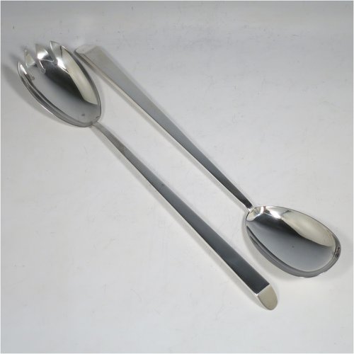 An Antique Edwardian Sterling Silver pair of Arts and Crafts salad servers, having very plain bodies with oval bowls, featuring tapered handles with chamfered ends. Made by Elkington & Co., of Birmingham in 1907. The length of these fine hand-made antique silver salad servers are 27 cms (10.75 inches), and the total weight is approx. 132g (4.3 troy ounces).   