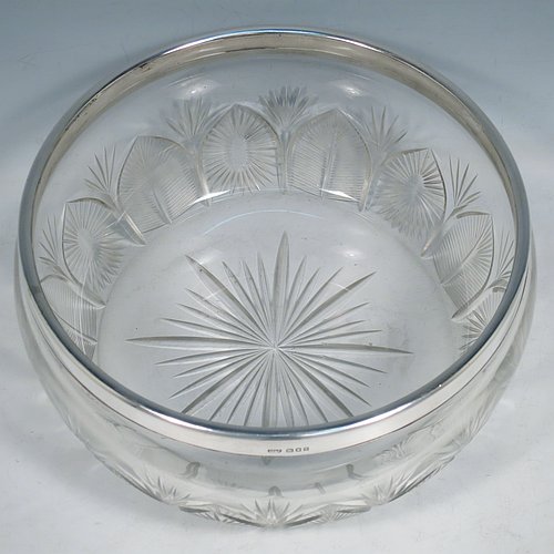 A Sterling Silver and hand-cut crystal salad bowl, having a round body with a plain applied silver rim, sitting on a hand-cut crystal base with floral and leaf engraving, and a star-cut flat base. Made by BS & Co., of London in 1921. The dimensions of this fine hand-made silver and crystal salad bowl are diameter 21 cms (8.25 inches), and height 11 cms (4.25 inches).   